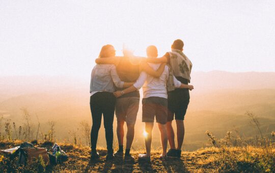 A group of people standing on top of a hill.