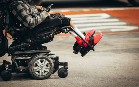 A person in a wheelchair with one leg up.