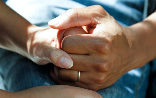 A person holding their hands together with a ring.